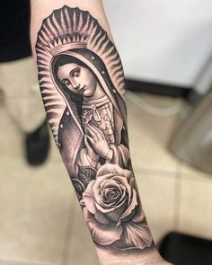 a woman's arm with a tattoo on it and a rose in the foreground