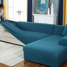 a woman unpacking a blue couch in a living room