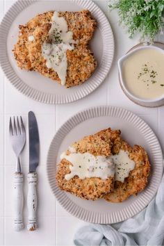 two white plates topped with chicken patties next to a bowl of gravy