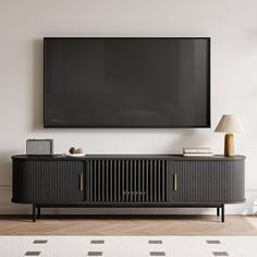 a flat screen tv mounted on the wall above a black entertainment unit in a living room