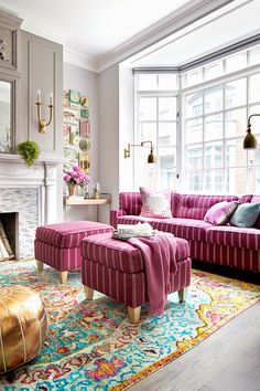 a living room filled with furniture and a fire place in front of a large window