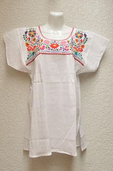 White blouse with multicolored details handmade by Mexican artisans. . It is important to mention that absolutely all the process is done by hand, so the size, shape and color can varybetween pieces. . Measurements:↕ 30 1/53 in↔ 16 1/2) in(armhole: 19 2/3) Handmade White Short Sleeve Tops, Handmade White Blouse For Summer, Traditional Handmade White Blouse, Handmade White Blouse For Spring, Traditional White Handmade Blouse, Traditional Multicolor Handmade Tops, Handmade White Cotton Blouse, Traditional Multicolor Embroidered Blouse, Traditional Multicolor Blouse With Machine Embroidery