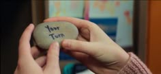 a person holding a rock with the words your turn written on it in their hands