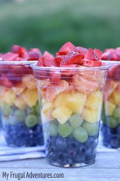 three plastic cups filled with fruit on top of a table