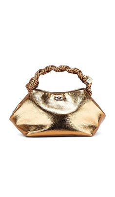 Find GANNI Bou Small Bag on Editorialist. The Ganni Bou Small Bag is crafted from a metallic leather blend with a twill lining. The bag features a top magnetic button closure, two compartments, and an interior card slot. The bag is accented with a nine hand-braided strand top handle with a braided knot and gold-tone hardware. The bag also includes a detachable and adjustable shoulder strap. The bag measures approximately 7.5 W x 5.5 H x 6.25 D. The shoulder strap has a 20 drop and the top handle Metallic Leather Bag With Dust Bag Included, Gold Satchel With Top Carry Handle For Evening, Gold Evening Satchel With Top Carry Handle, Metallic Clutch Bag For Formal Occasions, Luxury Metallic Clutch Bag, Gold Satchel With Removable Pouch For Evening, Luxury Metallic Clutch Shoulder Bag, Gold Evening Satchel With Removable Pouch, Metallic Evening Bag With Gold-tone Hardware