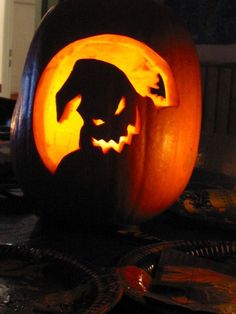 a carved pumpkin with a dog's head in the center and its shadow projected on it