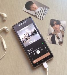 an mp3 player sitting on top of a table next to headphones and pictures with people