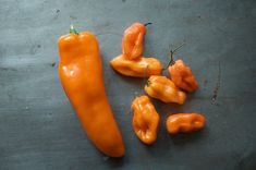 several orange peppers on a metal surface