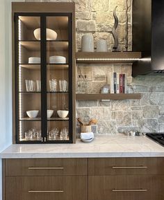 a kitchen with stone walls and shelves filled with dishes