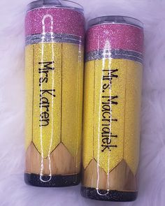 two yellow and pink glittered pencils with words written on the bottom one is black