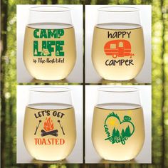 four wine glasses with different designs on them in front of some trees and grass,