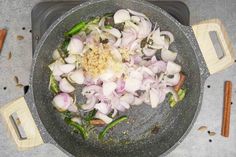 onions and other vegetables are being cooked in a wok