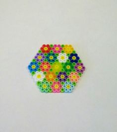 a multicolored object made out of small plastic beads on a white table top