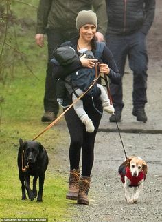 a woman walking two dogs on a leash