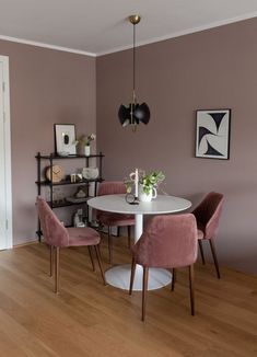 a dining room with pink chairs and a white table