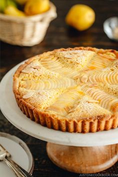 a lemon tart sitting on top of a white cake plate