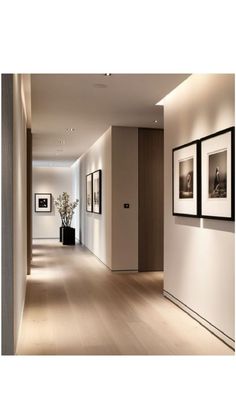 an empty hallway with pictures hanging on the wall and plants in vases next to it