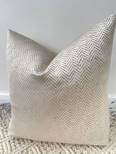 a white pillow sitting on top of a rug