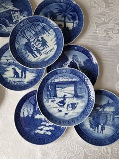 four blue and white plates sitting on top of a table