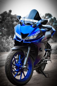 a blue motorcycle parked on top of a dirt road