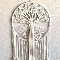 a white dream catcher hanging on the wall