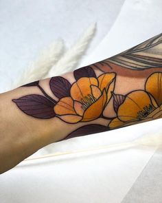 a woman's arm with yellow flowers and leaves on the left side of her arm