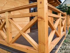 a close up of a wooden deck with railings on a house's front porch