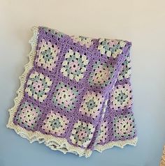 a crocheted blanket hanging on the wall