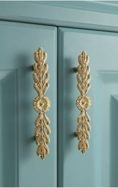 an ornate gold door handle on a blue cabinet