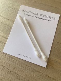 two white toothbrushes sitting on top of a piece of paper