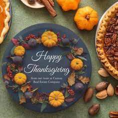 a happy thanksgiving card with pumpkins, nuts and pecans on a green table