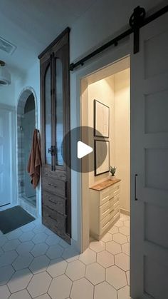 an open door leading to a bathroom with white tile flooring and wooden accents on the walls