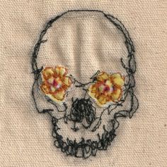 a close up of a skull with flowers on it's head and eyes embroidered onto the fabric