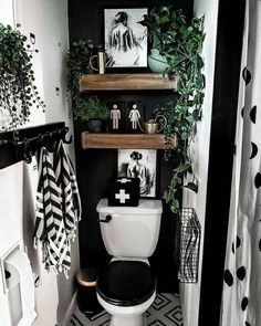 a small bathroom with black and white decor on the walls, shelves above the toilet