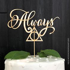 a harry potter cake topper with the word always on it and a green leaf