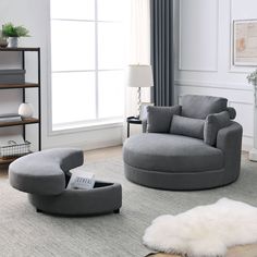 a living room filled with furniture and a white rug on top of a hard wood floor