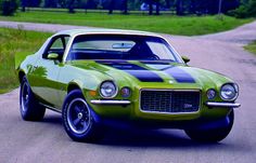 a green and black car parked on the side of a road