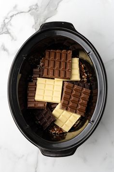 chocolates and nuts in an electric crockpot on a marble counter top,