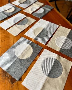 several pieces of fabric sitting on top of a wooden table covered in white and grey circles