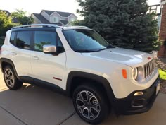 a white jeep parked in front of a house