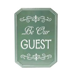 a green sign that says be our guest