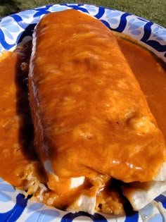 a plate with some enchiladas on top of it and sauce in the middle