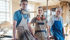 three people standing next to each other in an old fashioned building with tools on their heads