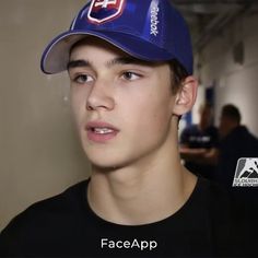 a young man wearing a blue hat and black shirt