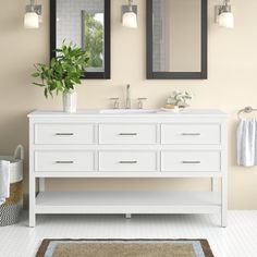 a bathroom vanity with two mirrors above it and a rug on the floor next to it