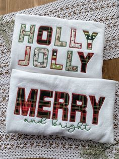 two embroidered christmas napkins sitting on top of a table