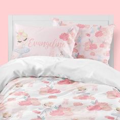 a bed with pink and white sheets, pillow cases and pillows on top of it