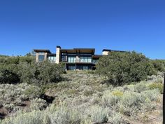 a large house sitting on top of a lush green hillside