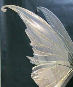 a glass sculpture with a white feather on it's back and wings spread out