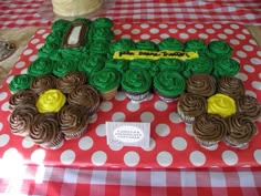 cupcakes in the shape of a tractor on a table with red and white checkered tablecloth